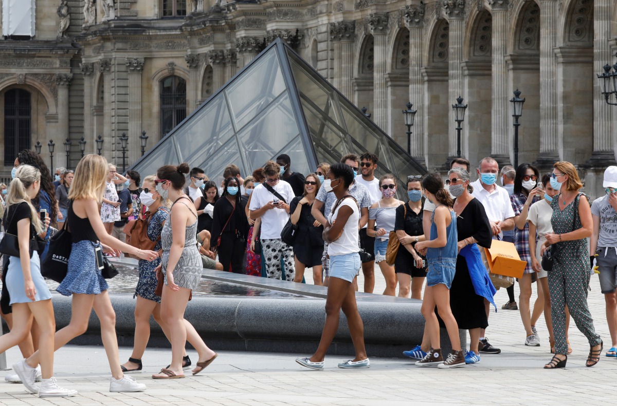 Visitors wearing protective face masks queue to enter the Louvre Pyramid in Paris, as France reinforces mask-wearing as part of efforts to curb a resurgence of the coronavirus disease (COVID-19) across the country, France, August 13, 2020. REUTERS/Charles