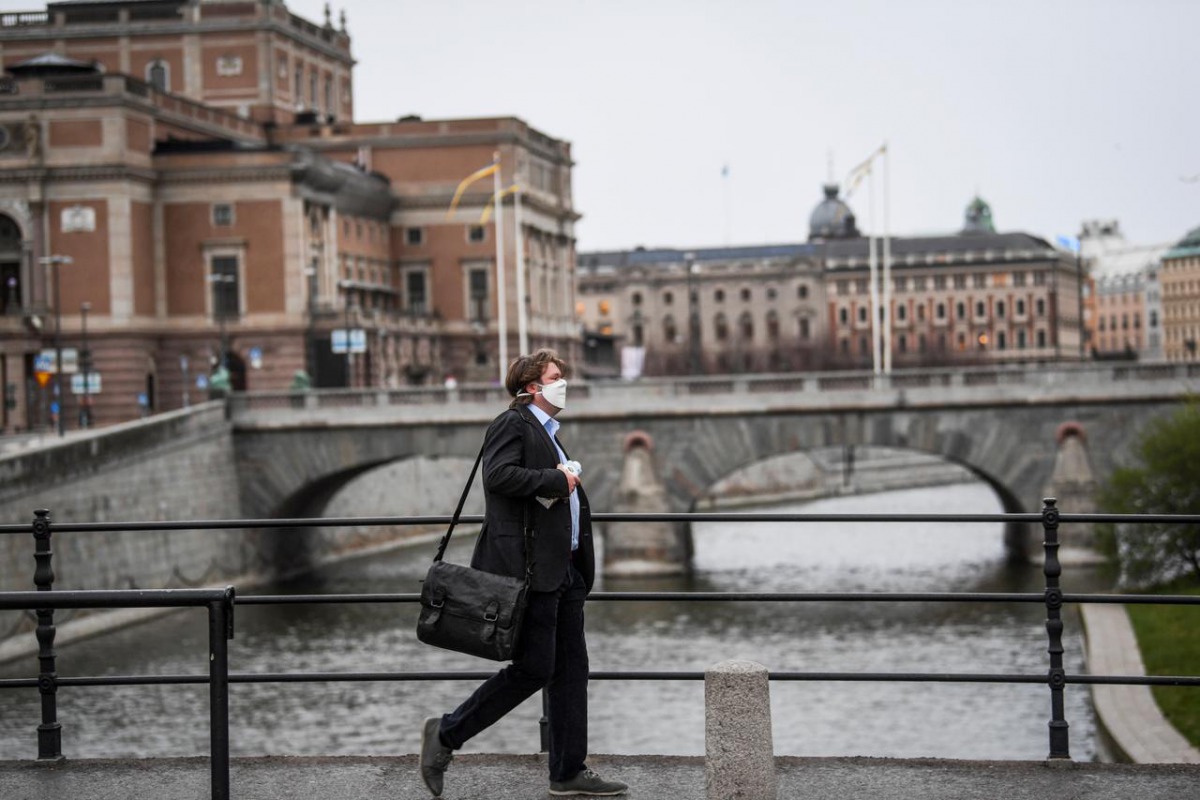 FILE PHOTO: A man wearing a protective mask walks past the Royal Swedish Opera, amid the coronavirus disease (COVID-19) outbreak in Stockholm, Sweden, April 27, 2020. Fredrik Sandberg/ REUTERS