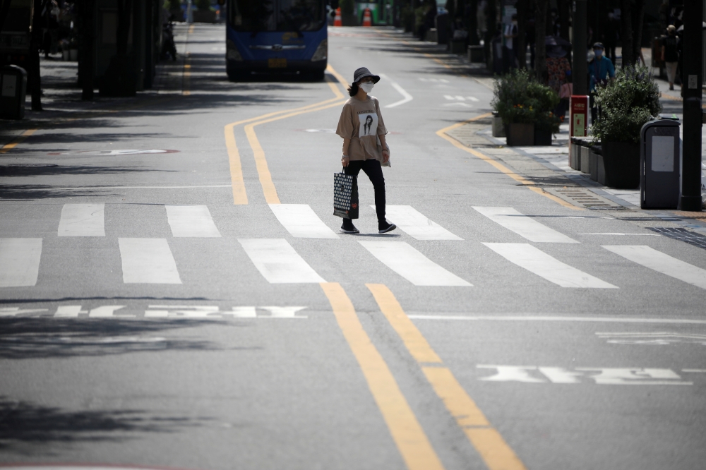 A woman wearing a mask to prevent the spread of the coronavirus disease (COVID-19) walks in a shopping district in Seoul, South Korea, August 20, 2020. REUTERS/Kim Hong-Ji