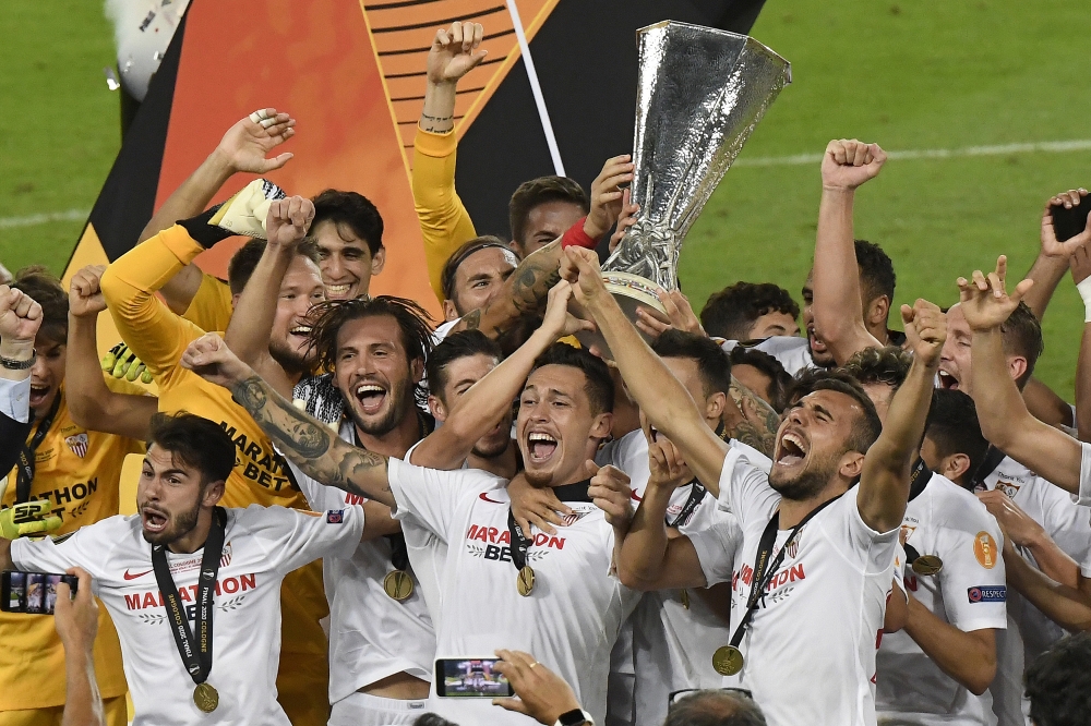 Players of Sevilla celebrate their victory after their team crowned 2020 UEFA Europa League champions with a 3-2 win against Italy's Inter Milan at the Rhein-Energie stadium in Cologne, Germany on August 21, 2020. Jesus Spinola - Anadolu