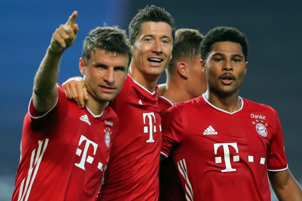 Bayern Munich’s Serge Gnabry (R) celebrates with Thomas Mueller (L) and Robert Lewandowski after scoring a goal during the UEFA Champions League semi-final against Lyon at the Jose Alvalade stadium in Lisbon on August 19, 2020. (AFP)