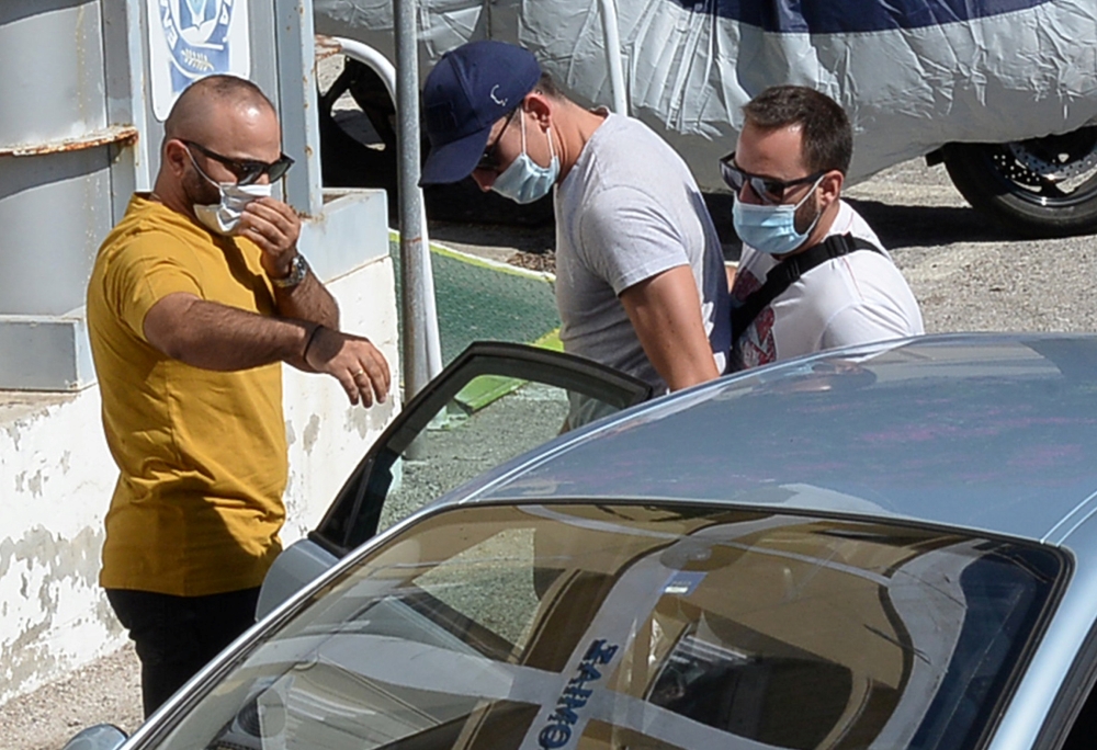 The man with a blue cap who is believed to be Manchester United captain Harry Maguire is escorted by plain-clothes police officers to the police station of the island of Syros, Greece, August 21, 2020. Giorgos Solaris/Intimenews
