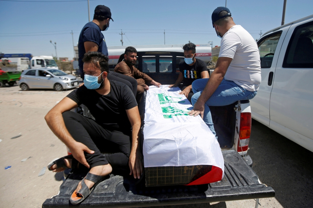Mourners sit next to the coffin of Reham Yacoub, a female activist who was killed by unidentified gunmen, during her funeral in Basra, Iraq August 20, 2020. REUTERS/Essam al-Sudani/File Photo