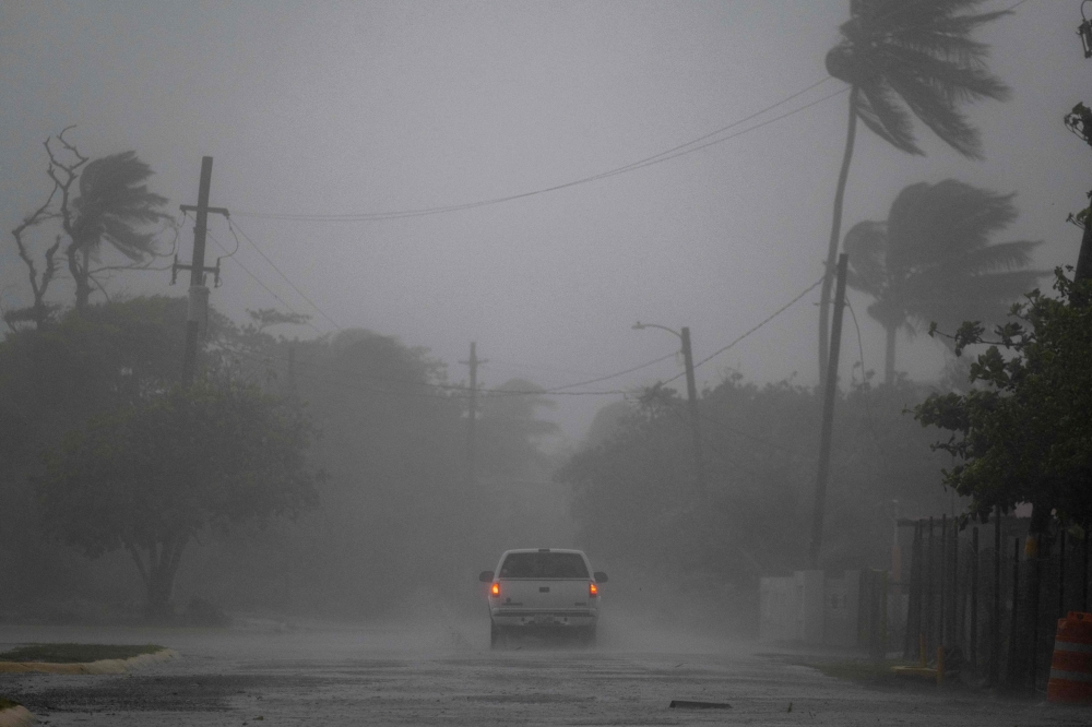 A pickup truck drives on a road as Tropical storm Laura hits Guayama, Puerto Rico on August 22, 2020. / AFP / Ricardo ARDUENGO