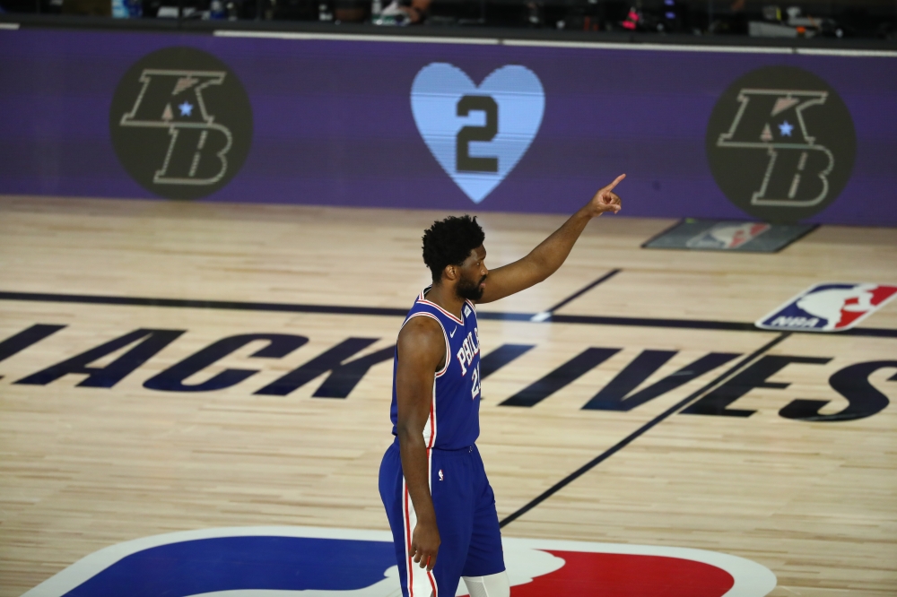 Philadelphia 76ers center Joel Embiid (21) stands midcourt before the game against the Boston Celtics as banners commemorating the birthday of late Los Angeles Lakers player Kobe Bryant are displayed in game four of an NBA basketball first-round playoff s