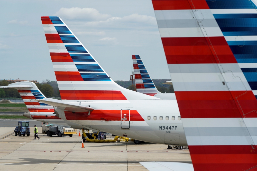 A member of a ground crew walks past American Airlines planes parked at the gate during the coronavirus disease (COVID-19) outbreak at Ronald Reagan National Airport in Washington, U.S., April 5, 2020. REUTERS/Joshua Roberts