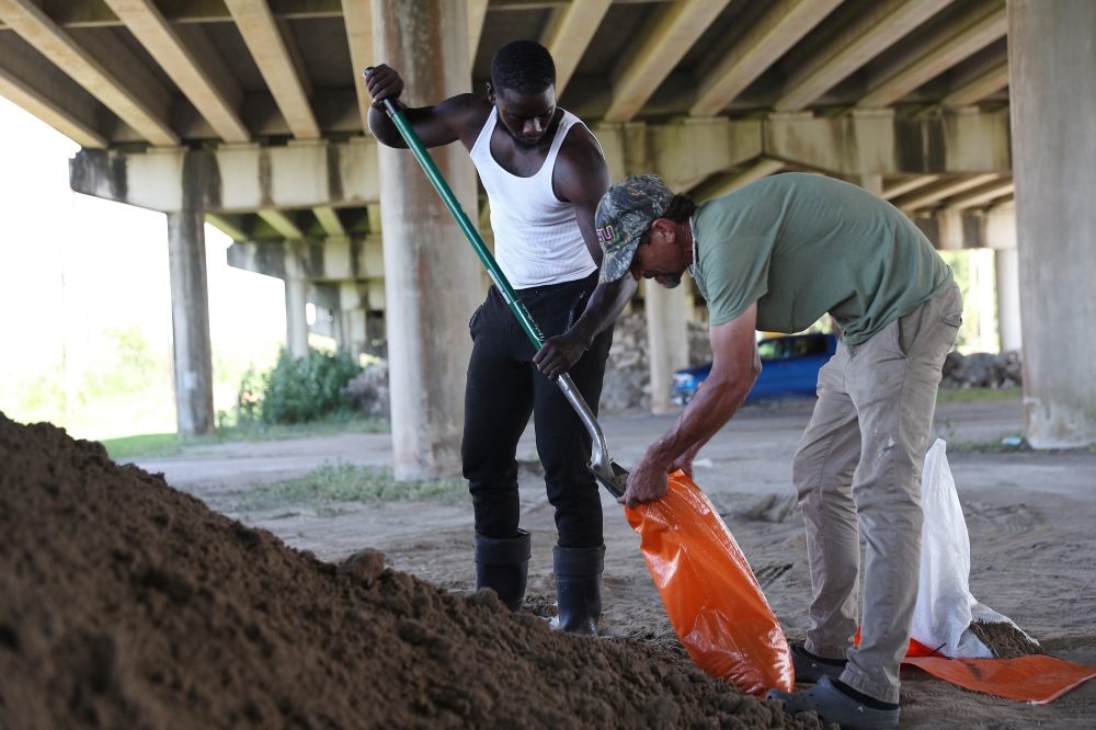Cobie Brown and Ken Allen (L-R) fill sandbags as they prepare for the arrival of Tropical Storm Marco and possibly Hurricane Laura on August 24, 2020 in Morgan City , Louisiana. The Gulf Coast is expecting to see some impact from Tropical Storm Marco foll