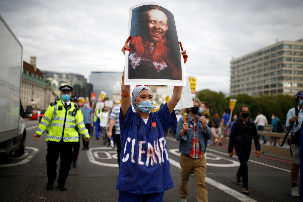 NHS staff member holds an image depicting Britain's?Secretary?of State for?Health Matt Hancock during a protest asking for a pay rise, amid the spread of the coronavirus disease (COVID-19), in London, Britain August 26, 2020. REUTERS/Henry Nicholls NO RES