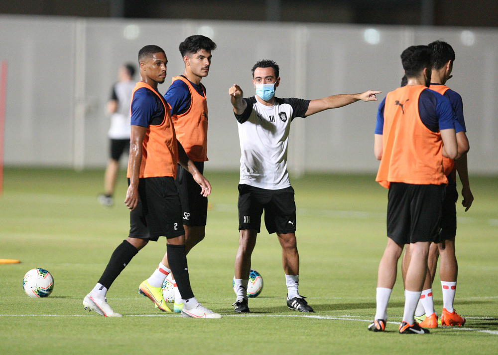 Al Sadd's coach Xavi with players during a training session.