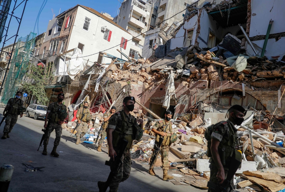 Lebanese soldiers walk past a partially destroyed traditional building which was afffected by the Beirut port blast, in the Gemmayzeh neighbourhood, on August 26, 2020. AFP / JOSEPH EID