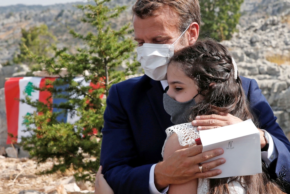 French President Emmanuel Macron hugs a blast victim while attending a ceremony to mark Lebanon's centenary in Jaj Cedars Reserve Forest, northeast of the capital Beirut, on September 1, 2020. / AFP / POOL / GONZALO FUENTES
