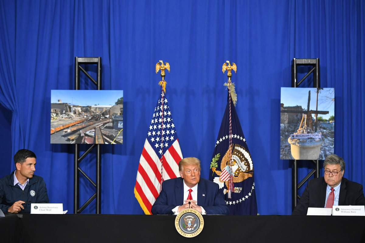 US President Donald Trump with US Attorney General William Barr (R) and Acting Homeland Security Secretary Chad Wolf (L), speaks to officials during a roundtable discussion on community safety, at Mary D. Bradford High School in in Kenosha, Wisconsin on S