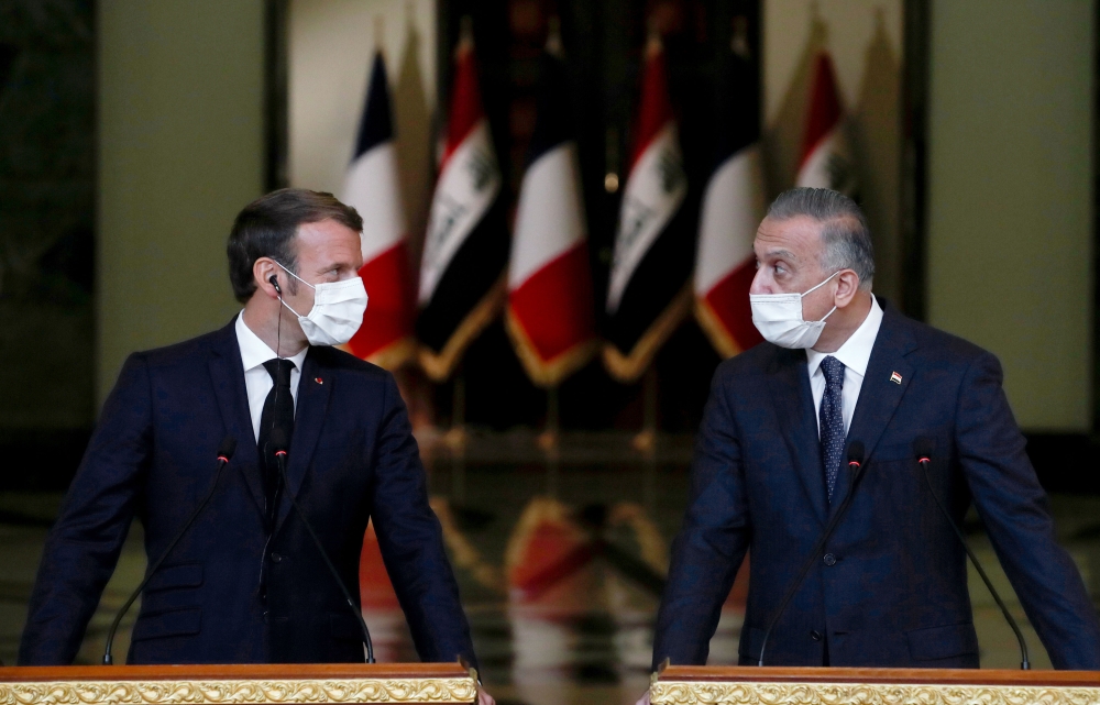 French President Emmanuel Macron (L) and Iraq's Prime Minister Mustafa al-Kadhemi, mask-clad due to the COVID-19 coronavirus pandemic, give a joint press conference in Baghdad on September 2, 2020.  AFP / POOL / GONZALO FUENTES