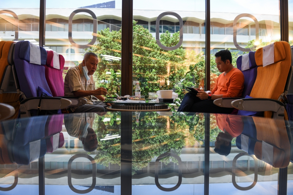Customers eat at Thai Airways pop-up airplane-themed restaurant at the airlines headquarters with onboard meals prepared by their chefs, while their fleet is still grounded at the airport and the company awaits a bankruptcy court decision, in Bangkok, Tha