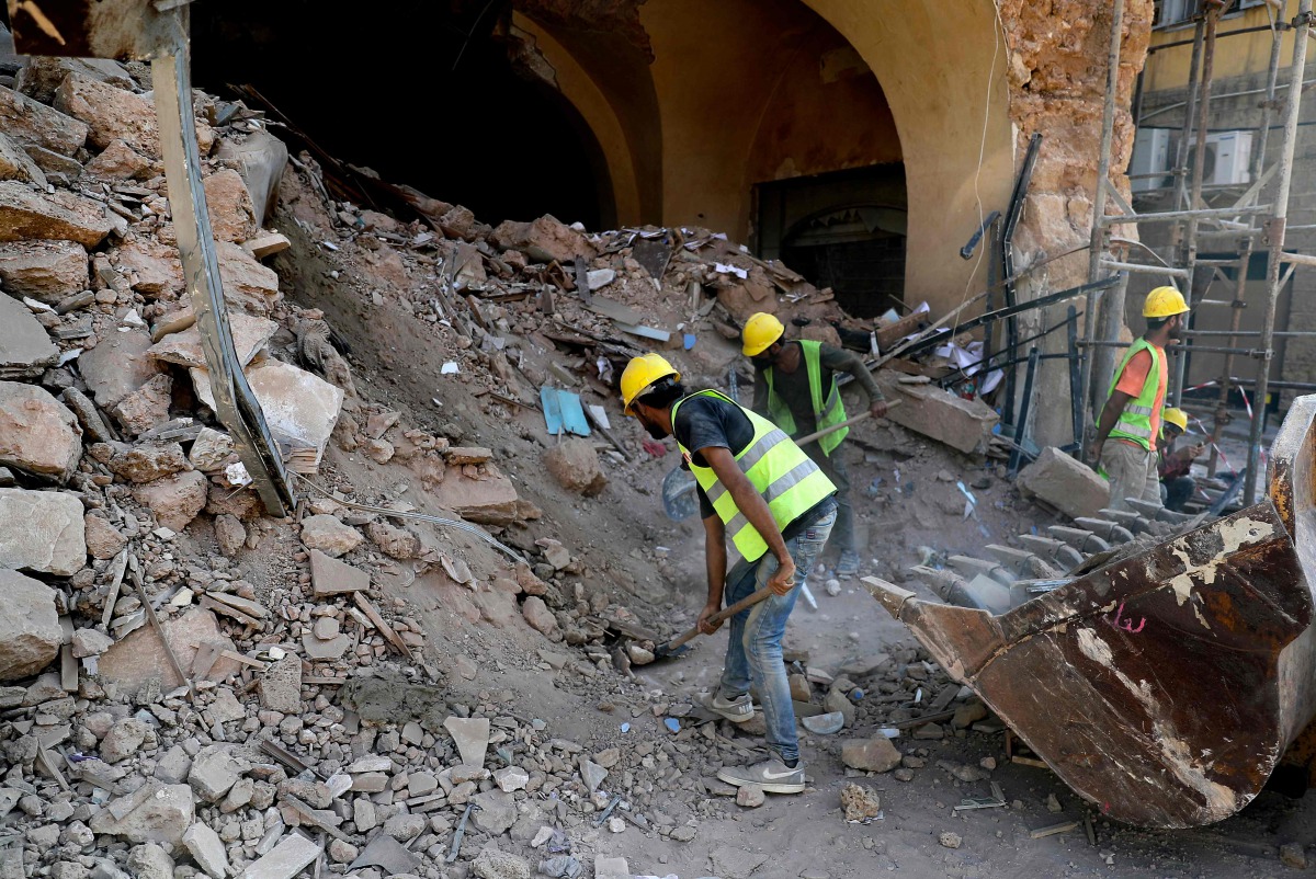 Workers remove the rubble beneath a partially-destroyed traditional Lebanese building in the Gemmayzeh neighbourhood of the capital Beirut, in the aftermath of the devastating port blast, on August 26, 2020. A massive fertiliser explosion at the Beirut po