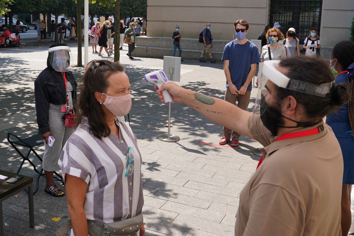 FILE PHOTO: People have their temperature checked before attending The Metropolitan Museum of Art on their first day open since closing due to the coronavirus disease (COVID-19) outbreak in the Manhattan borough of New York City, New York, U.S., August 27