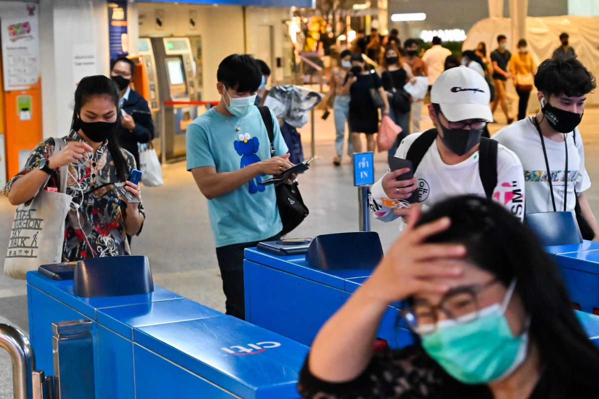 People wearing face masks amidst concerns over the spread of COVID-19 novel coronavirus enter a commuter train station in Bangkok on September 2, 2020. Thailand on September 2 registered its 100th consecutive day without a local infection of the COVID-19 