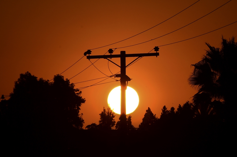 The sun sets behind power lines in Los Angeles, California on September 3, 2020, ahead of a heatwave to arrive September 4 through the Labour Day weekend prompting a statewide flex alert. / AFP / Frederic J. BROWN