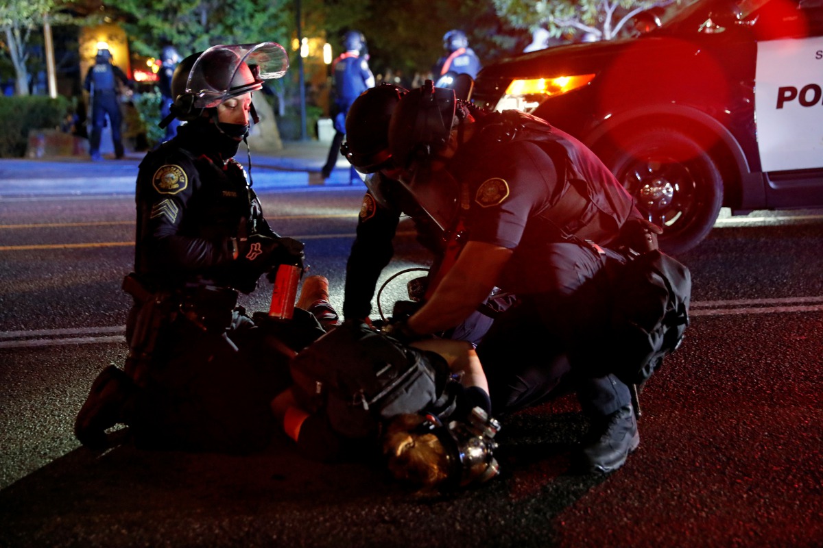 FILE PHOTO: Police officers detain a demonstrator during a protest against police violence and racial injustice in Portland, Oregon, U.S., August 24, 2020. REUTERS/Terray Sylvester/File Photo
