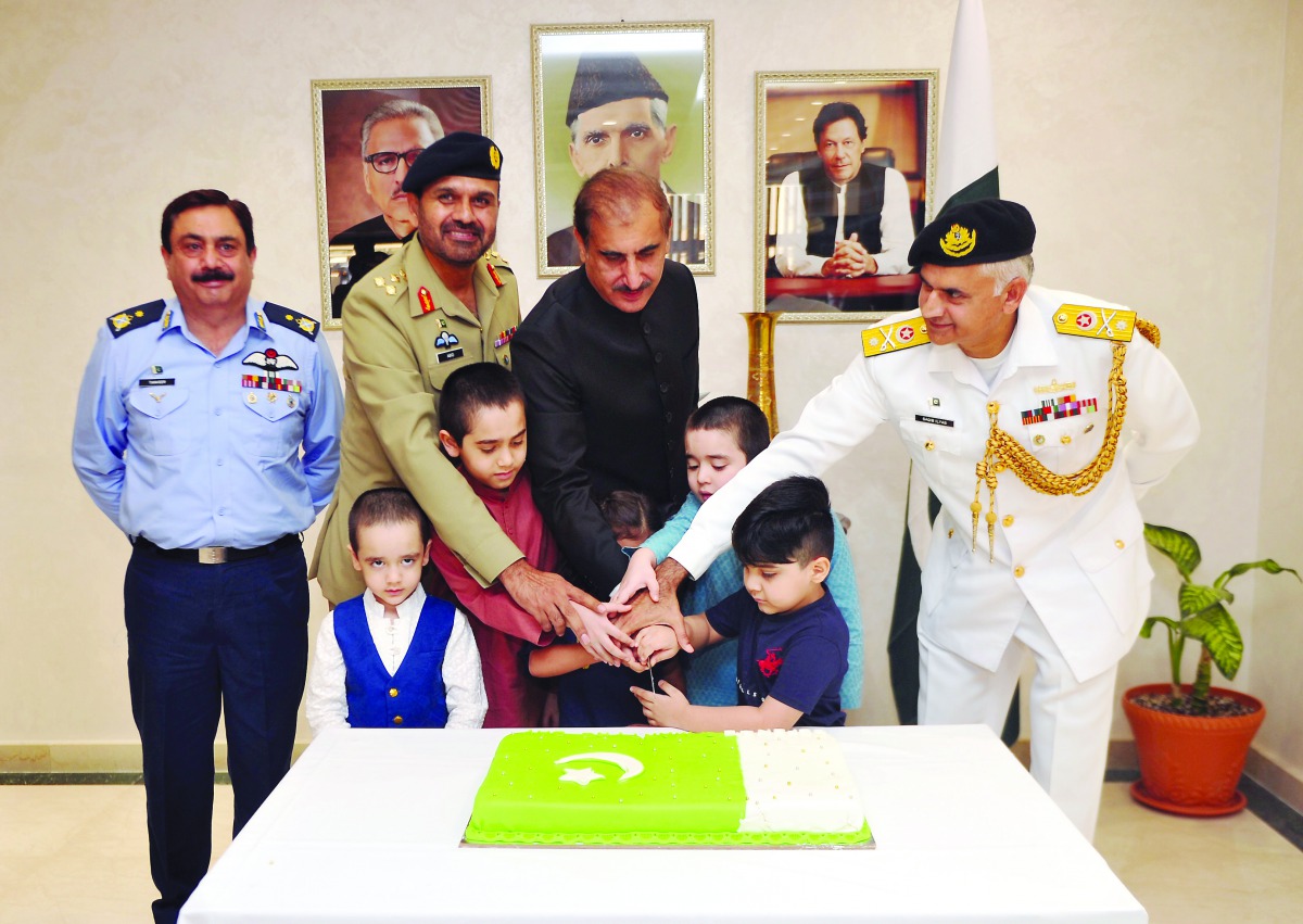 Ambassador of Islamic Republic of Pakistan to the State of Qatar, H E Syed Ahsan Raza Shah, cutting a cake along with Pakistan Armed Forces officers and children to mark Pakistan Defence Day at the Pakistan Embassy in Doha, yesterday. PICS: ABDUL BASIT / 