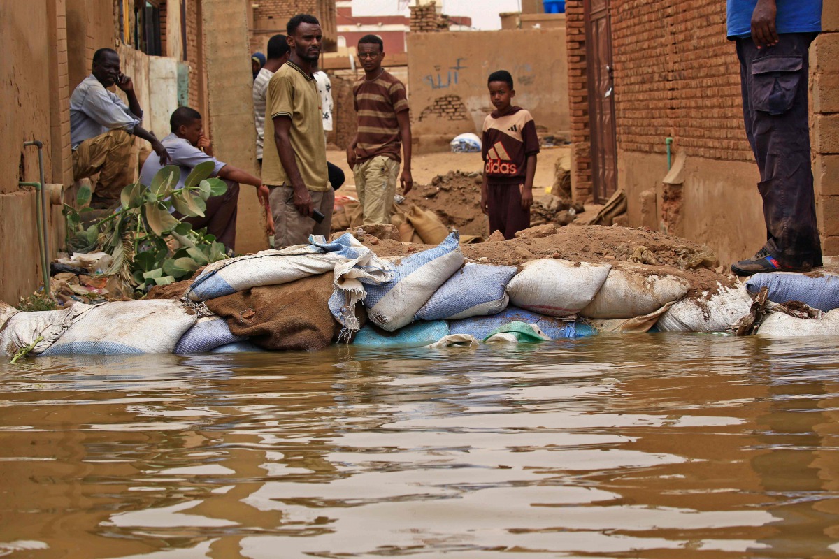 Sudanese stand amidst flood waters in Tuti island, where the Blue and White Nile merge in the Sudanese capital Khartoum, on September 3, 2020. / AFP / ASHRAF SHAZLY
