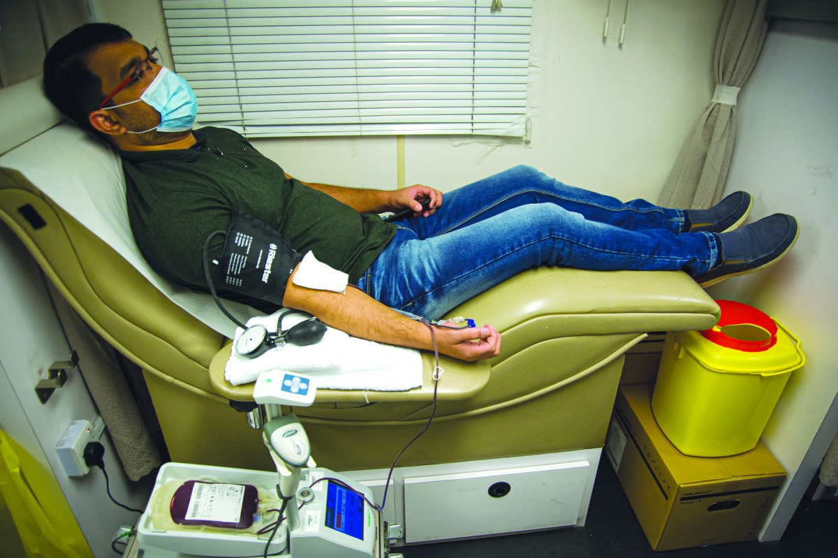 An employee of Barwa Real Estate Group donating blood under a blood donation campaign conducted in Barwa headquarters in Al Sadd.