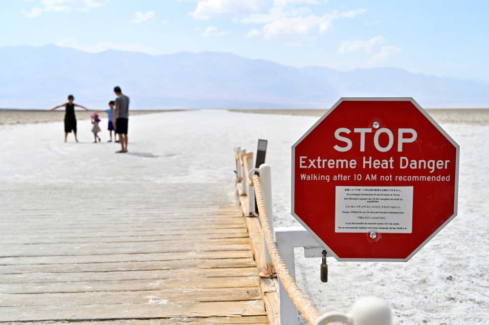 A warning sign alerts visitors of the extreme heat dangers at Badwater Basin, the lowest point in North America at 279 feet below sea level, in Death Valley National Park, California, U.S. August 17, 2020. REUTERS/David Becker/File Photo
