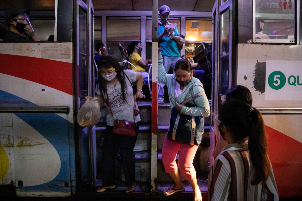 Passengers wearing face shields and face masks for protection against the coronavirus disease (COVID-19) get off a bus in Quezon City, Metro Manila, Philippines, September 7, 2020. REUTERS/Eloisa Lopez