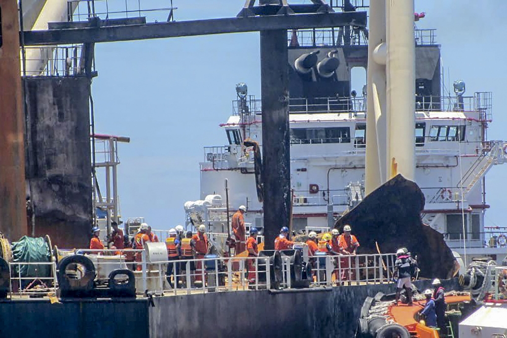 This handout picture taken on September 10, 2020, and released on September 11, 2020 by Sri Lanka Navy shows international salvage experts boarding the fire-stricken tanker, New Diamond, in the Indian Ocean off Sri Lanka's eastern coast. AFP PHOTO / Sri L