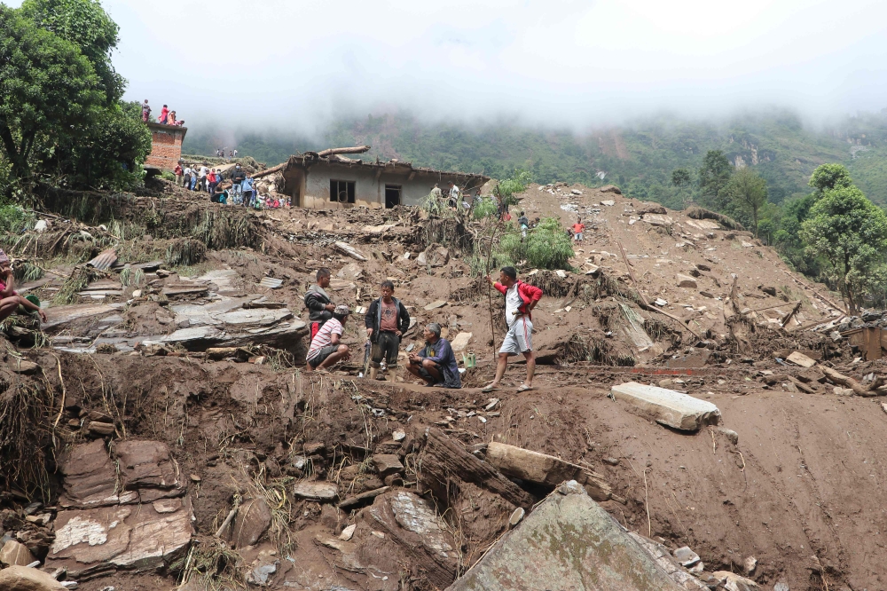 Residents and rescue workers search for bodies of landslides victims, following heavy rains in Bahrabise municipality of Sindhupalchok district, some 90 km northeast of Kathmandu on September 13, 2020. / AFP / NIROJ CHAOULAGAIN