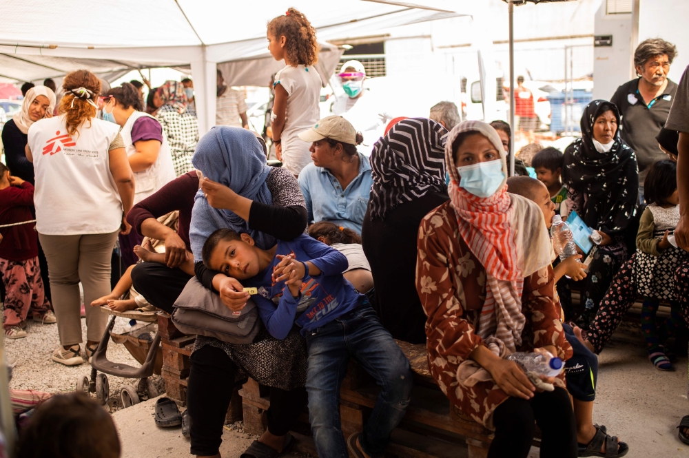 Migrants wait to receive treatment at the Doctors Without Borders (MSF) clinic near a new makeshift camp on the island of Lesbos on September 15, 2020.  AFP / ANGELOS TZORTZINIS
