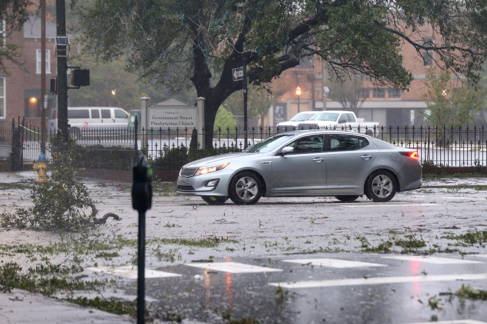 A car drives down Government Street during Hurricane Sally in Mobile, Alabama, U.S., September 16, 2020. REUTERS/Jonathan Bachman