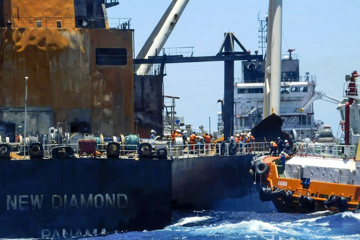 This handout picture was taken on September 10, 2020, and released on September 11, 2020 by Sri Lanka Navy shows international salvage experts boarding the fire-stricken tanker, New Diamond, in the Indian Ocean off Sri Lanka's eastern coast./ AFP / Sri La