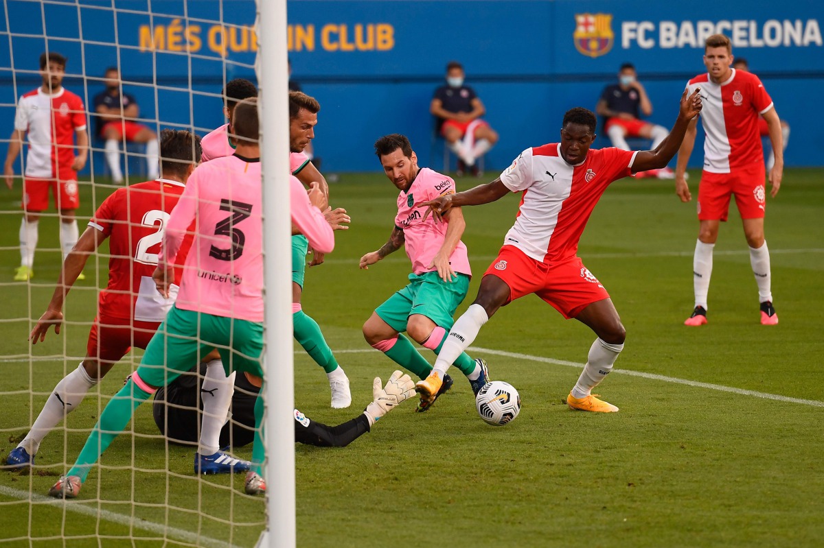Barcelona's Argentinian forward Lionel Messi (C) challenges Girona's Malian midfielder Ibrahima Kebe (R) during a friendly football match between FC Barcelona and Girona at the Johan Cruyff stadium in Sant Joan Despi near Barcelona on September 16, 2020. 