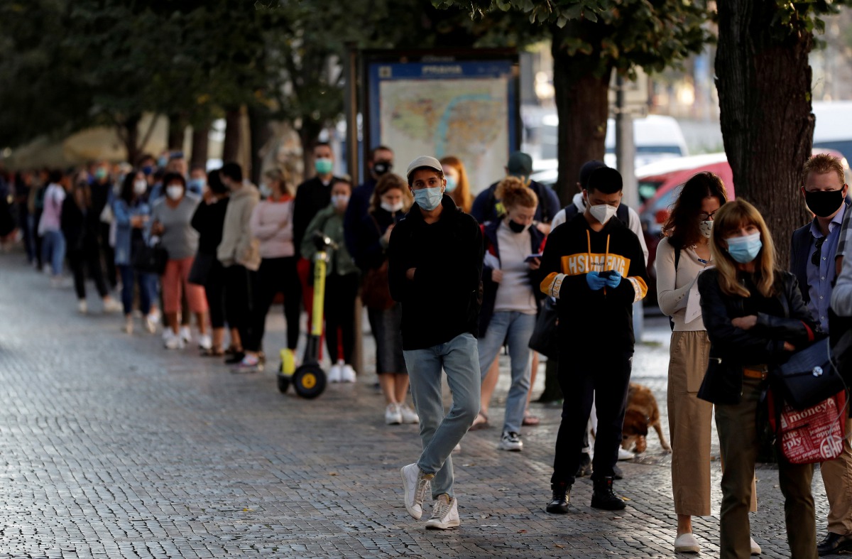 FILE PHOTO: People wait in a line to get tested for the coronavirus disease (COVID-19) before a sampling station opens at Wenceslas Square in PRAGUE, Czech Republic, September 16, 2020. REUTERS/David W Cerny/File Photo
