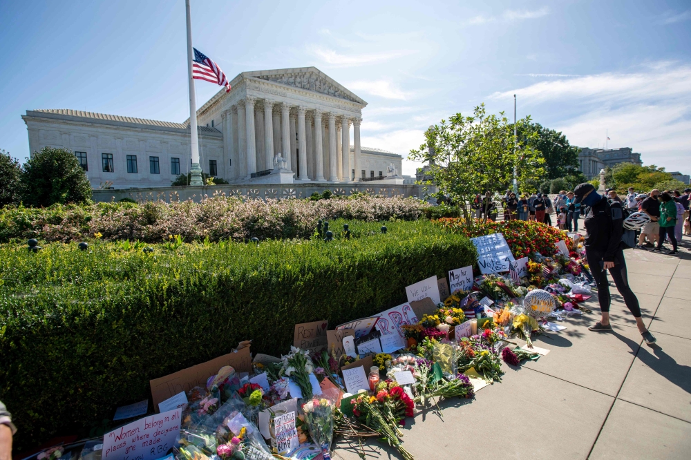 People place flowers outside of the US Supreme Court in memory of Justice Ruth Bader Ginsburg, in Washington, DC, on September 19, 2020.   AFP / Jose Luis Magana