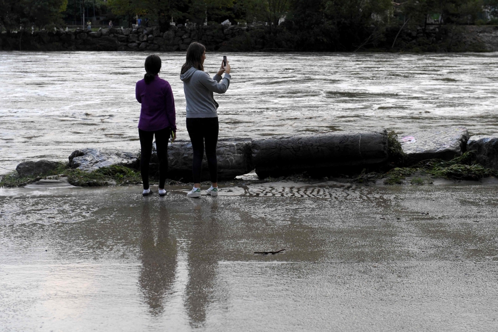 People take pictures of the Gardon river following floods in Anduze, southeastern France on September 19, 2020. AFP / NICOLAS TUCAT