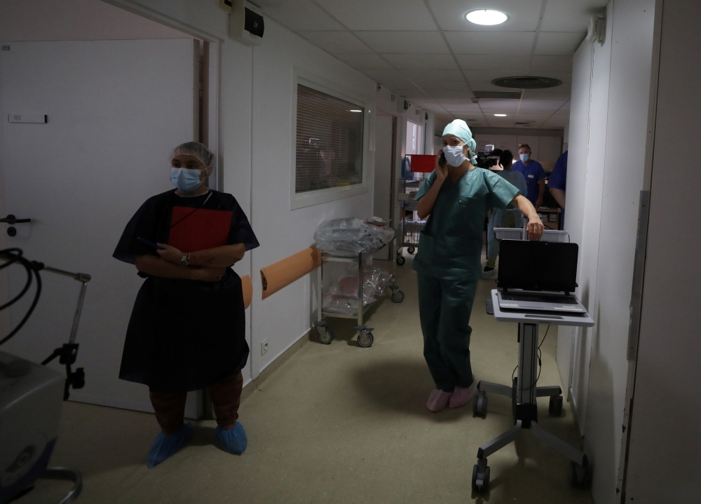 Medical workers, wearing protective face masks, work in the Intensive Care Unit (ICU) where patients suffering from the coronavirus disease (COVID-19) are treated at the Clinique Bouchard-ELSAN private hospital in Marseille, France, September 21, 2020. Pi