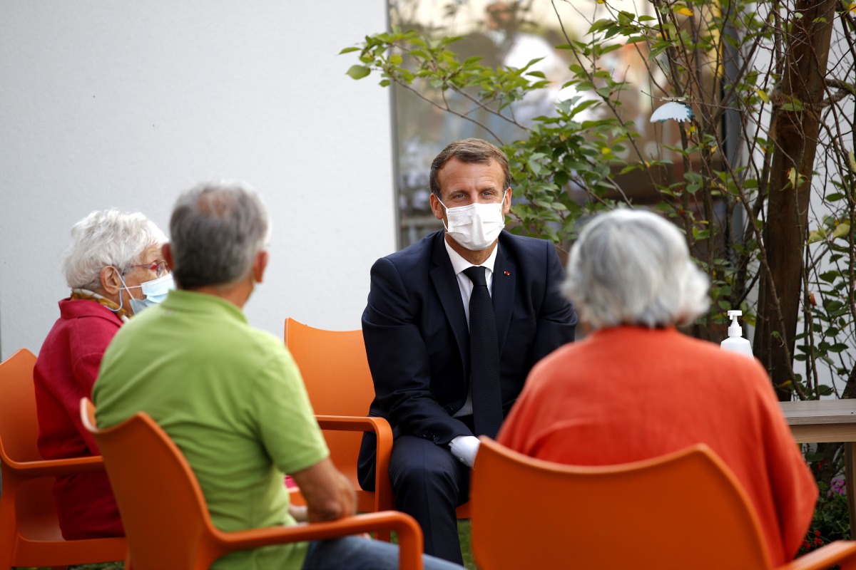 French President Emmanuel Macron (C) meets with elderly people in 'La Bonne Eure' nursing home (EPHAD) in Bracieux, Loir-et-Cher, on September 22, 2020, as part of a visit to welcome the mobilisation of nursing home staff and to call for the preservation 