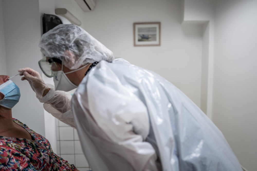 A medical assistant takes a sample from a patient for a coronavirus (Covid-19) test at an analysis laboratory in Le Peage-de-Roussillon, some 30kms south of Lyon, south-eastern France on September 22, 2020. / AFP / JEFF PACHOUD