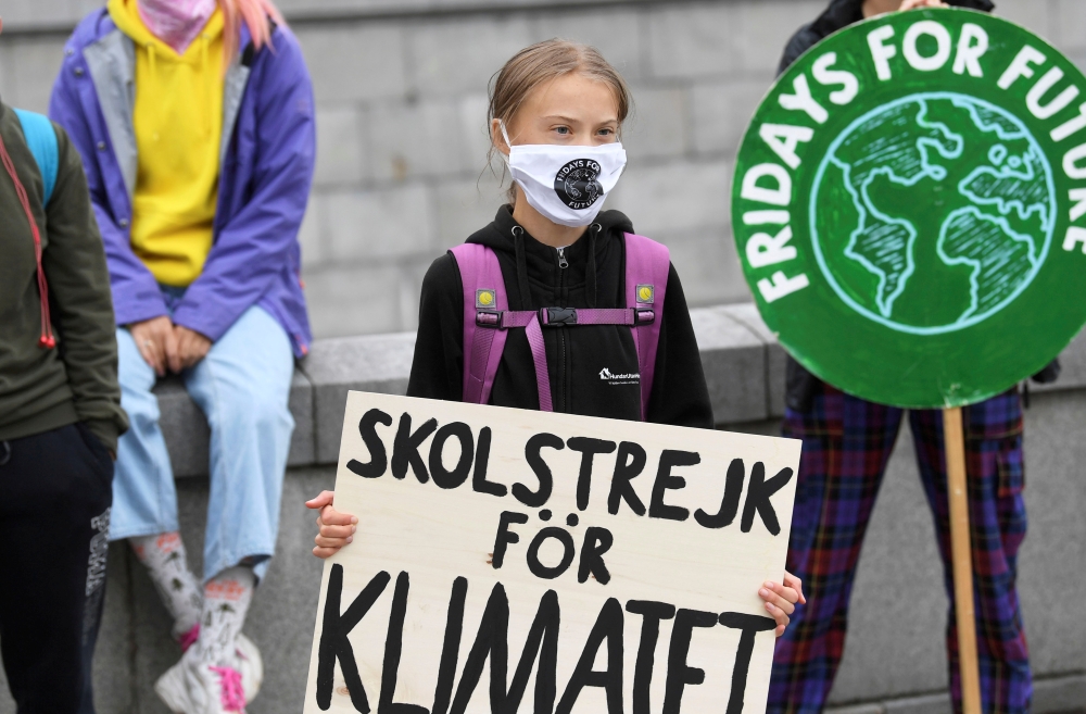 Swedish climate activist Greta Thunberg holds a poster reading 