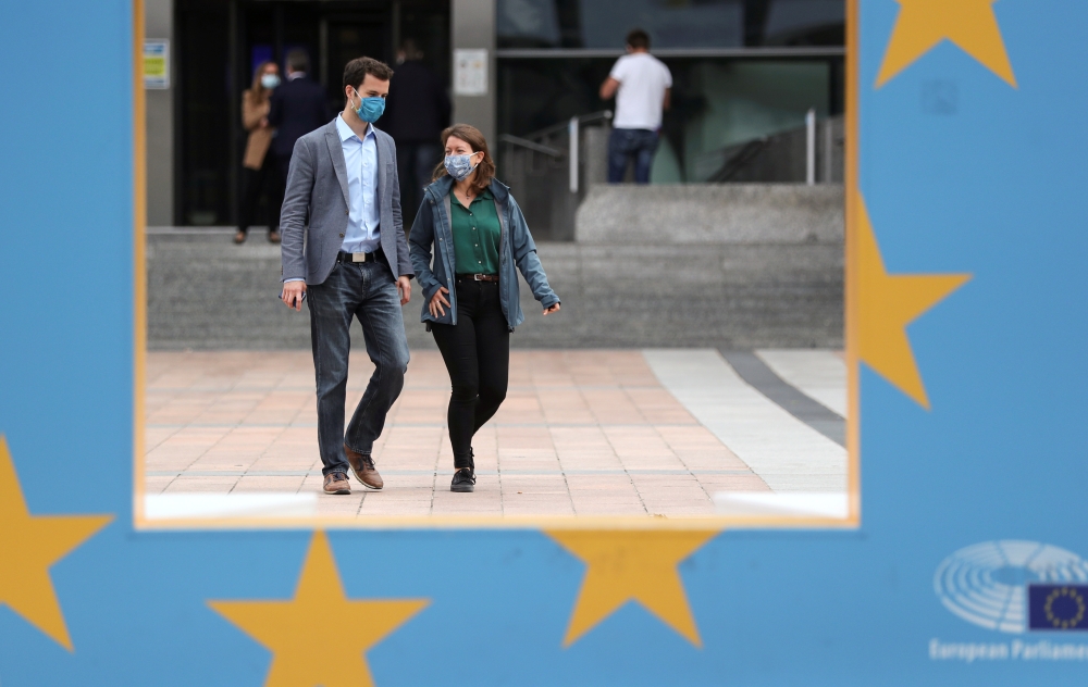 People wearing protective masks walk past the European Parliament headquarters amid the coronavirus disease (COVID-19) outbreak in Brussels, Belgium September 23, 2020. REUTERS/Yves Herman