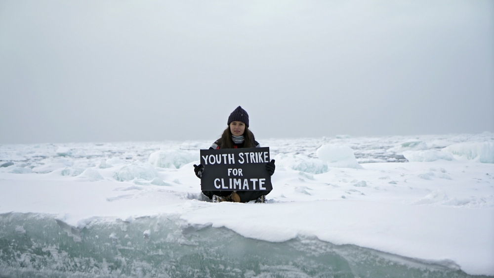 Environmental activist and campaigner Mya-Rose Craig, 18, holds a cardboard sign reading 