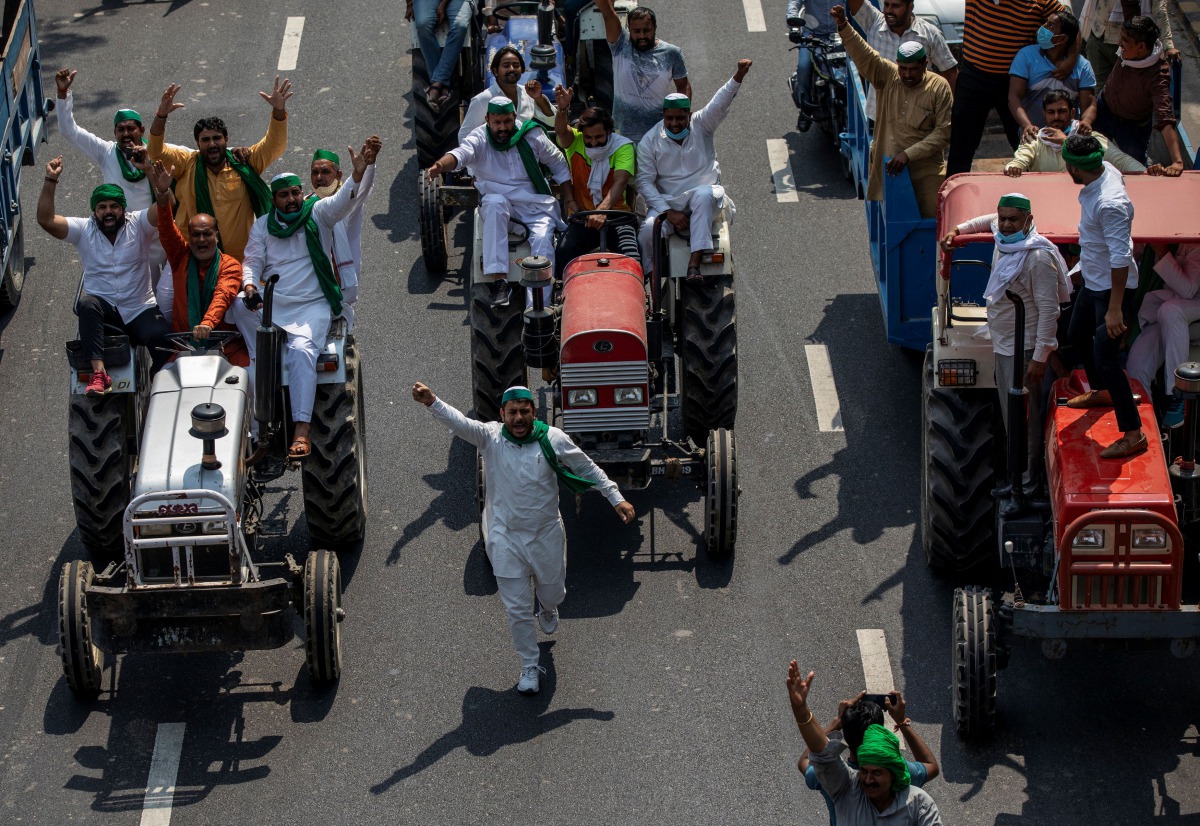 Farmers on tractors shout slogans as they arrive to block the Delhi-Uttar Pradesh border during a protest against farm bills passed by India's parliament, in Noida, India, September 25, 2020. REUTERS/Danish Siddiqui
