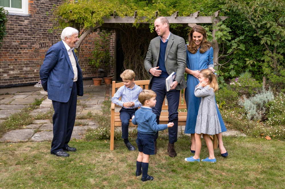 A handout photo released by Britain's Prince William and Cathrine, Duchess of Cambridge, Prince George (seated), Princess Charlotte and Prince Louis with David Attenborough after Prince William and David Attenborough attended an outdoor screening of the u
