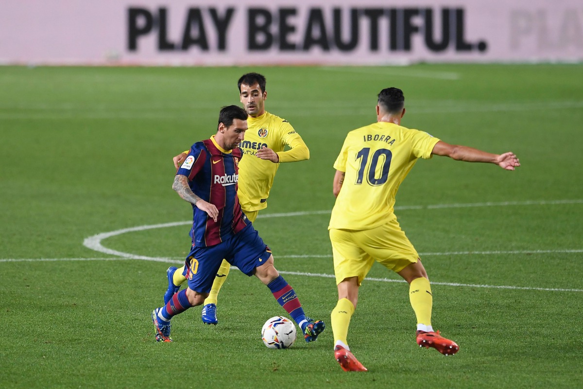 Villarreal's Spanish midfielder Manuel Trigueros (C) and Villarreal's Spanish midfielder Vicente Iborra (R) challenge Barcelona's Argentinian forward Lionel Messi during the Spanish league football match FC Barcelona against Villarreal CF at the Camp Nou 