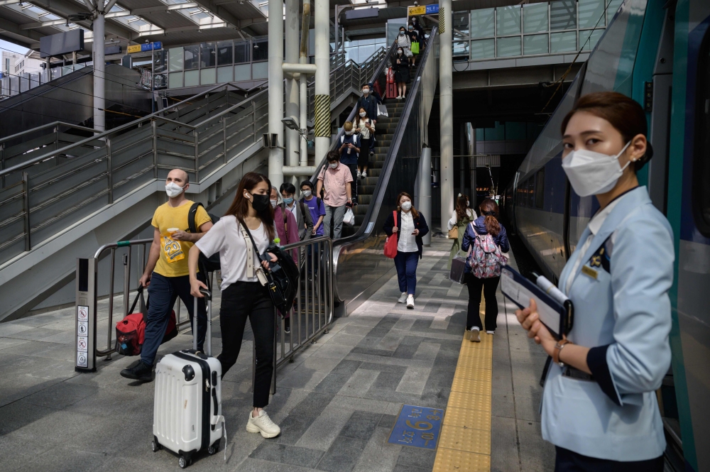 Travellers arrive to board a train as South Korea prepares to mark the annual Chuseok festival holiday, at Seoul station on September 29, 2020. / AFP / Ed JONES