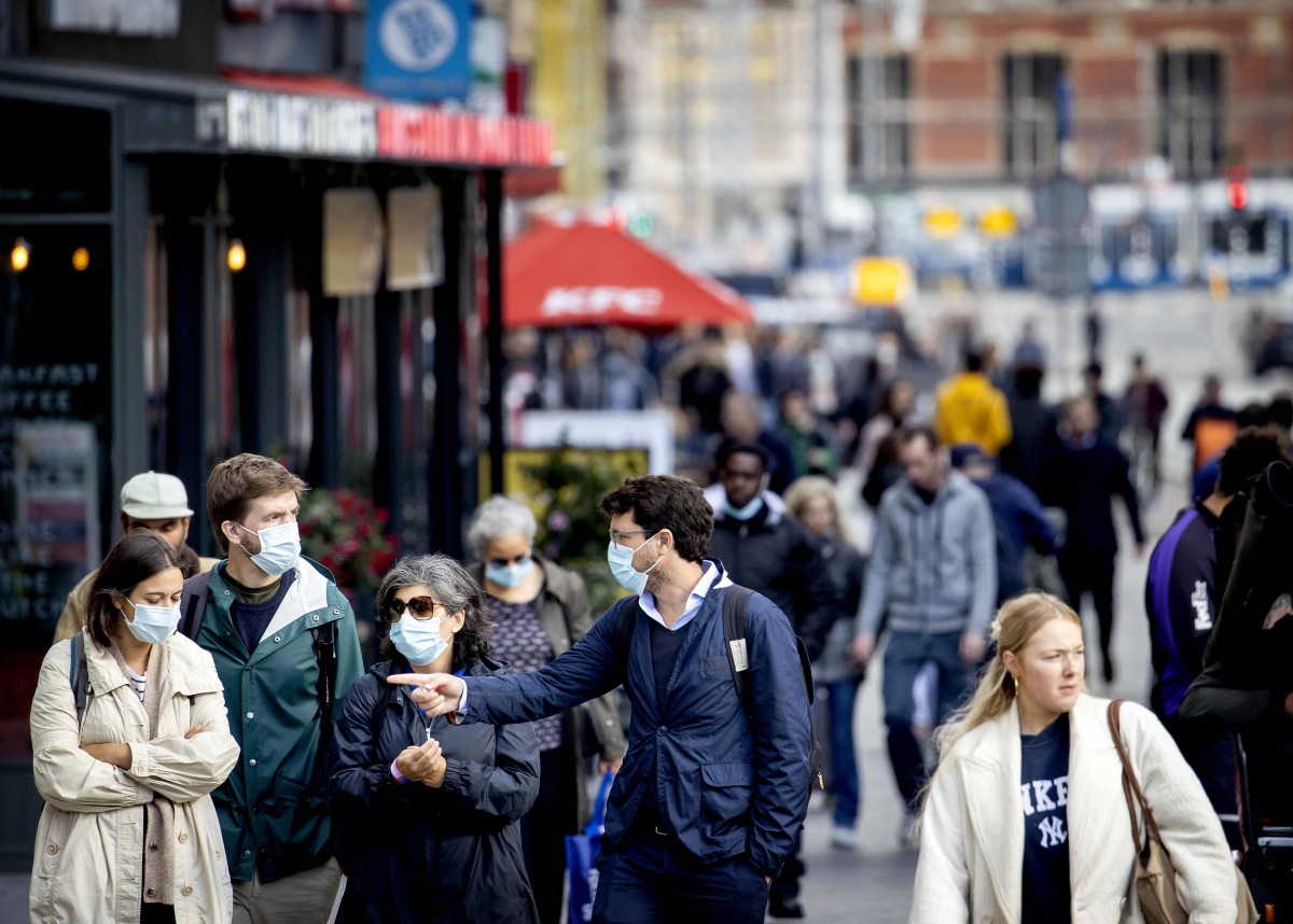 People, some wearing face masks, walk on a shopping street in Amsterdam, on September 29, 2020. / AFP / ANP / Koen van Weel