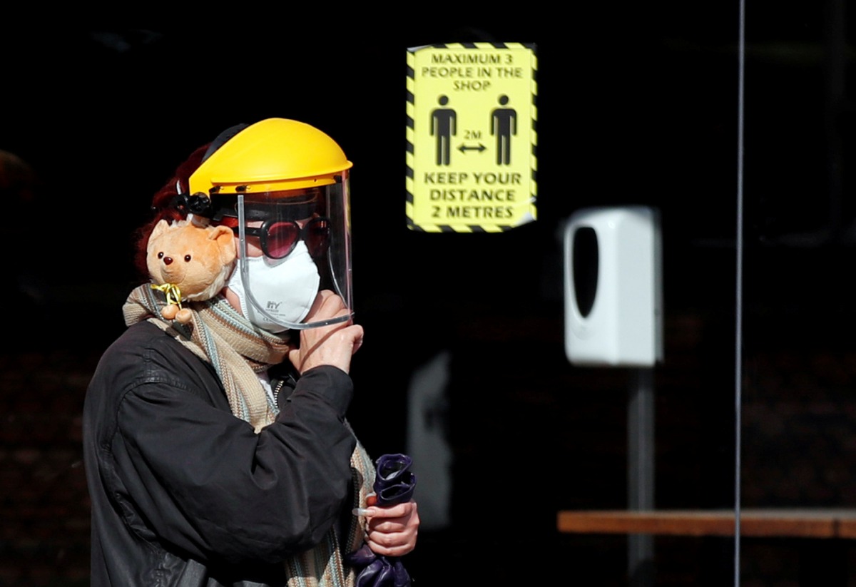 A woman wearing a face mask and a shield walks on the street, amid the spread of the coronavirus disease (COVID-19), in London, Britain, September 29, 2020. REUTERS/Peter Cziborra
