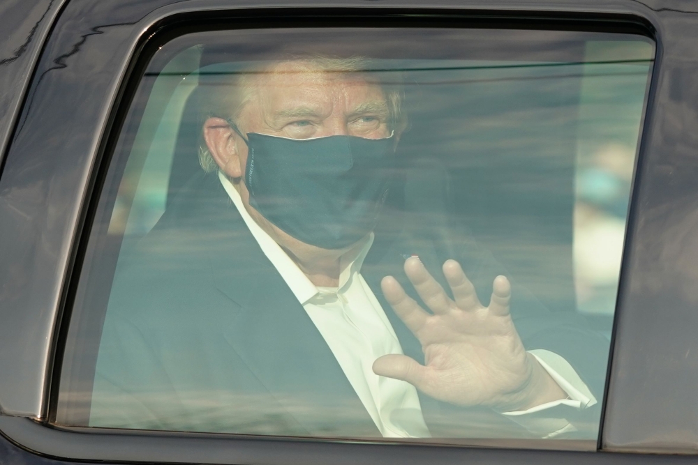A car with US President Trump drives past supporters in a motorcade outside of Walter Reed Medical Center in Bethesda, Maryland on October 4, 2020. / AFP / ALEX EDELMAN